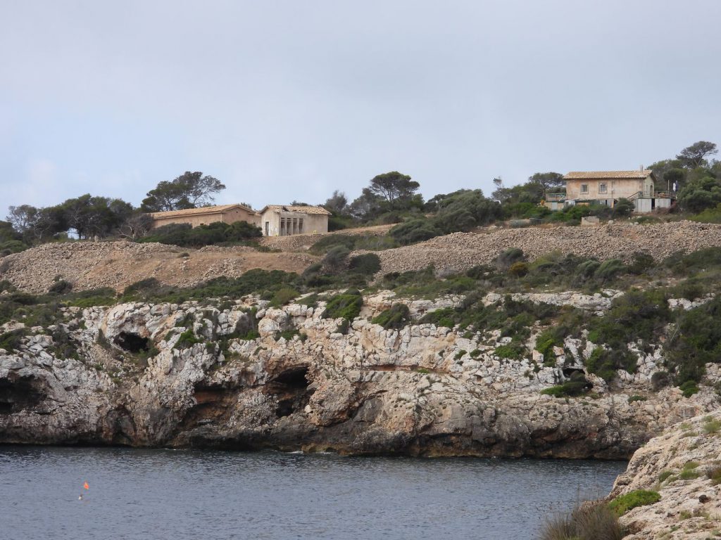 Entrada de Cala Figuera y los cercanos edificios abandonados de la antigua guarnición de la bateria de costa.